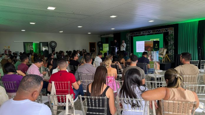 Auditório lotado durante palestra na I Imersão de Turismo Experiencial em Tucano, com painel projetado ao fundo e participantes atentos ao conteúdo sobre turismo sustentável e regional.